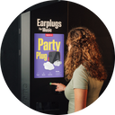 Vrouw bij alpine verkoopautomaat waar men partyplugs kan kopen