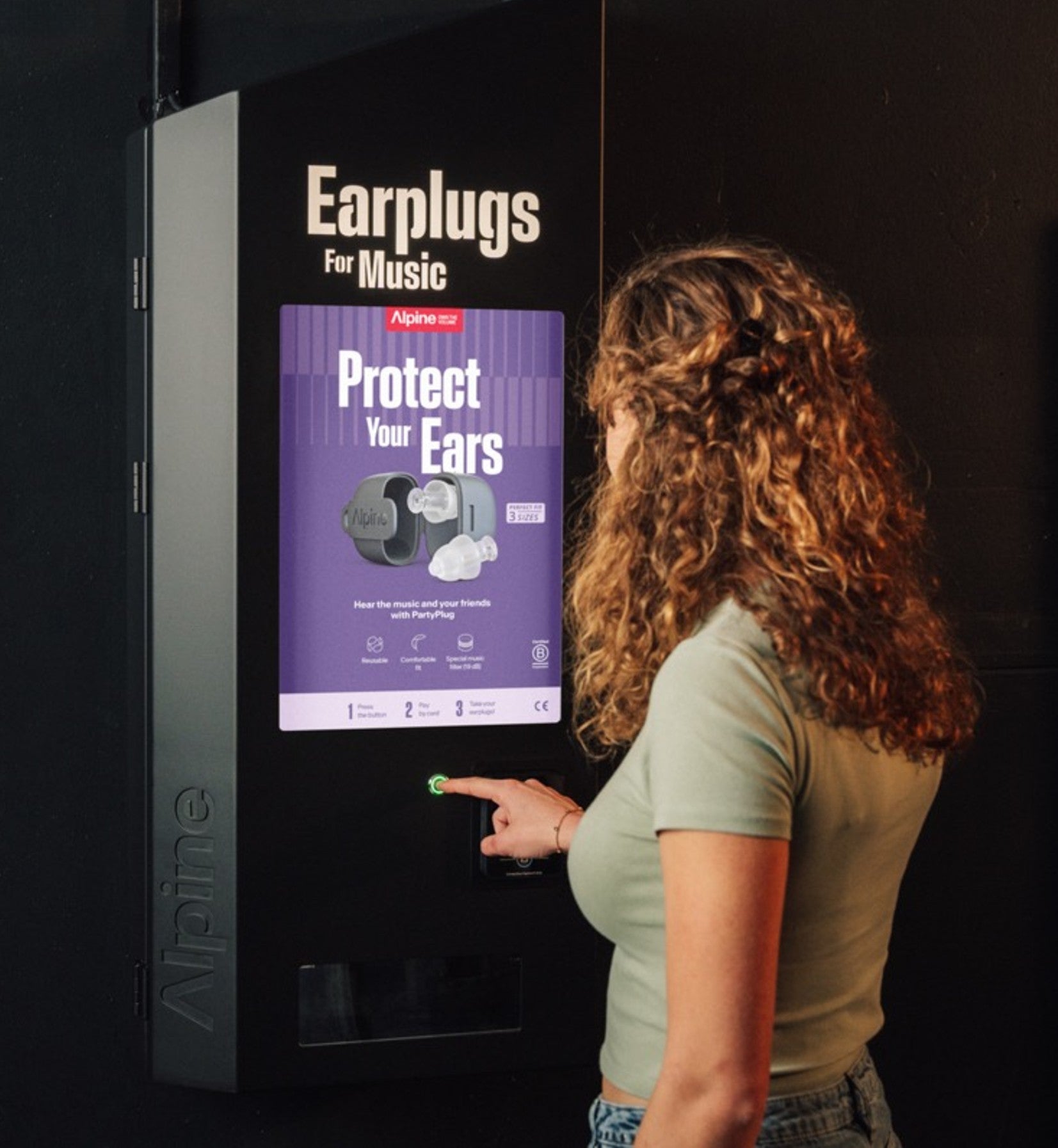 Vrouw bij alpine verkoopautomaat waar men partyplugs kan kopen